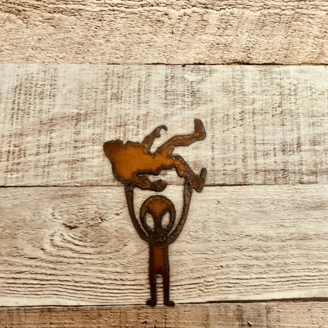 Alien Holding Bigfoot Rustic Metal Magnet